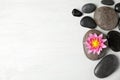 Stones with lotus flower and space for text on wooden background, flat lay. Zen lifestyle Royalty Free Stock Photo