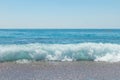 Stones, pebbles beach, blue sea and sky.Pebble beach with azure sea water and small waves with rocks.Water washing on Royalty Free Stock Photo