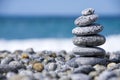 Stones pyramid on pebble beach symbolizing spa concept with blur sea background