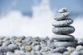 Stones pyramid on pebble beach symbolizing spa concept with blur sea background Royalty Free Stock Photo