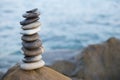 Stones pyramid on sand symbolizing zen, harmony, balance. Ocean at sunset in the background Royalty Free Stock Photo