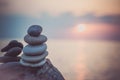 Stones pyramid on sand symbolizing zen, harmony, balance. Ocean at sunset in the background Royalty Free Stock Photo