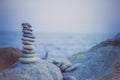 Stones pyramid on sand symbolizing zen, harmony, balance. Ocean at sunset in the background Royalty Free Stock Photo