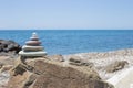 Stones pyramid on sand symbolizing zen, harmony, balance. Ocean at sunset in the background Royalty Free Stock Photo