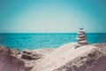 Stones pyramid on sand symbolizing zen, harmony, balance. Ocean at sunset in the background Royalty Free Stock Photo