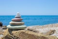 Stones pyramid on sand symbolizing zen, harmony, balance. Ocean at sunset in the background Royalty Free Stock Photo