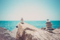 Stones pyramid on sand symbolizing zen, harmony, balance. Ocean at sunset in the background Royalty Free Stock Photo