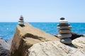 Stones pyramid on sand symbolizing zen, harmony, balance. Ocean at sunset in the background Royalty Free Stock Photo