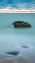 Stones In Sea Water. Long Exposure Photography. Soft Cloudy Sky. Vertical 9:16 Format. Phone Wallpaper Background.