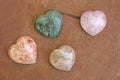 Stones in the shape of heart lie on a brown background. Heart made of natural quartz stone, rhodochrosite and marble. Love