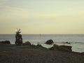 Stones on the shore of a calm sea at sunset on a clear day