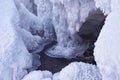 Stones with snow caps and ice in the water of frozen river in winter