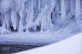 Stones with snow caps and ice in the water of frozen river in winter