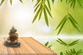 Stones stacked together into layers on wood with growing leaf bamboo frame  background with reflection in waterclipping path. Royalty Free Stock Photo