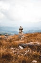 Stones stacked on top of each other on the brown grass surrounded by mountains during daytime Royalty Free Stock Photo