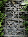 Stones wall in steel mesh wire cage texture and tree. modern loft design. Royalty Free Stock Photo