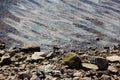 Stones at water background. Riverside with stones close-up. Ripples on water surface background. Royalty Free Stock Photo