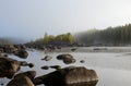 Stones in water in foreground and a little Island in fog Royalty Free Stock Photo