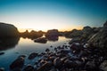 Stones in the water of the Pacific Ocean, with rocks in the water at sunset. Night landscape Royalty Free Stock Photo