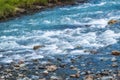 Stones in water riffle of mountain river. Powerful water stream among stones in mountain creek with rapids. Fast flow among rocks Royalty Free Stock Photo