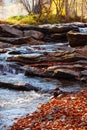 Stones waterfall reflection forest water autumn trees sun landscape yellow park leaves Royalty Free Stock Photo