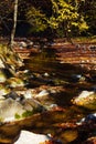 Stones waterfall reflection forest water autumn trees sun landscape yellow park leaves Royalty Free Stock Photo