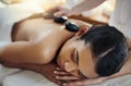 These stones will work away your tension. a young woman getting a hot stone massage at a spa. Royalty Free Stock Photo
