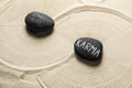 Stones with word Karma on sand, above view