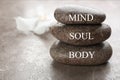 Stones with words MIND, BODY, SOUL on brown marble background, space for text. Zen lifestyle Royalty Free Stock Photo