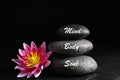 Stones with words Mind, Body, Soul and lotus flower on background. Zen lifestyle