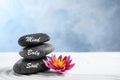 Stones with words Mind, Body, Soul and lotus flower on sand. Zen garden Royalty Free Stock Photo