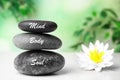Stones with words Mind, Body, Soul and lotus flower on wooden table. Zen lifestyle