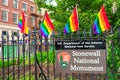 Stonewall National Monument sign on the fence decorated with rainbow flags at Christopher Park