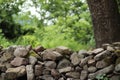 Stonewall with trees and green plants in the background Royalty Free Stock Photo