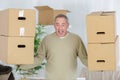 Stong mature man carrying boxes during moving