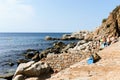 Tossa de Mar, Spain, August 2018. Stony beach, flippers for swimming and sunbathing people. Royalty Free Stock Photo