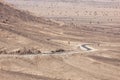 Stony desert landscapes with road and acacia trees.