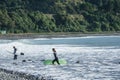 Stony Mangamaunu, beach near Kaikoura with surf rolling in and surfers