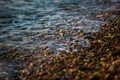 Waves roll on small stones during sunset Royalty Free Stock Photo