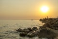 Stony seashore with fishermen