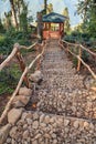 Stony stairway leading downwards wooden pavilion in summer forest in Caucasus mountains. Vertical scenic landscape