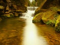 Stony weir on small mountain river. Stream is flowing over square blocks and makes milky water. Royalty Free Stock Photo