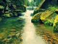 Stony weir on small mountain river. Stream is flowing over square blocks and makes milky water. Royalty Free Stock Photo