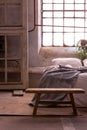 Stool in a bedroom interior with a wooden frame, bed and window in the background Royalty Free Stock Photo