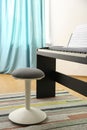 Stool and modern piano with music sheets