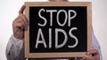 Stop AIDS warning phrase on blackboard in doctor hands, disease prevention