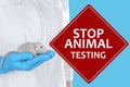 STOP ANIMAL TESTING.Scientist holding rat on light blue background, closeup