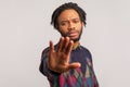 Stop! Closeup serious concerned african man with dreadlocks stretching his hand forward showing no gesture, warning, stop racism