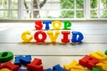 Stop Covid-19 Sign & Symbol, plastic letter on white wood background Royalty Free Stock Photo