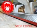 Stop COVID-19. Warning medical protection mask sign on baggage claim at Europeane airports background